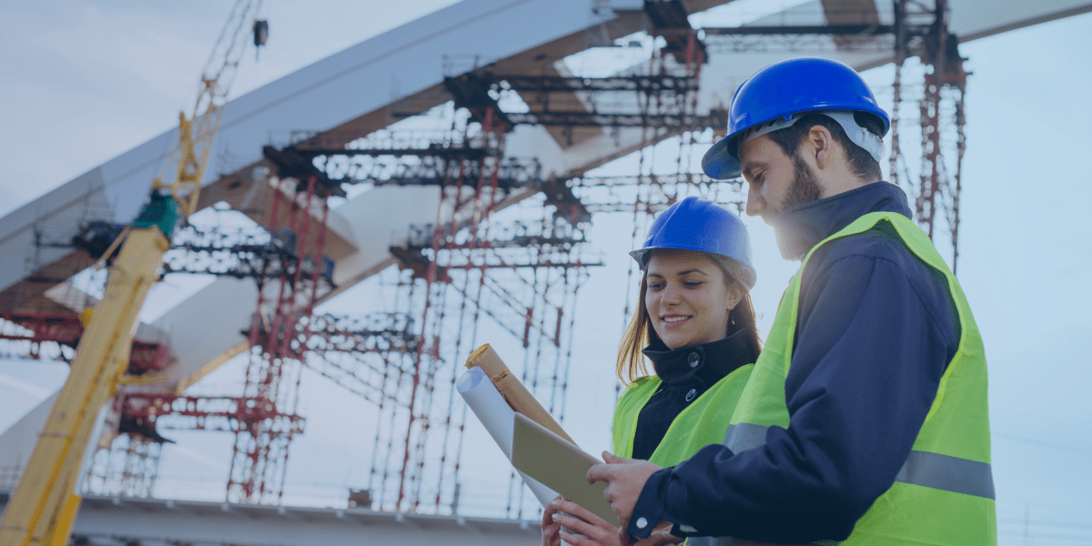 engenheiros olhando para o mapa e construção atrás